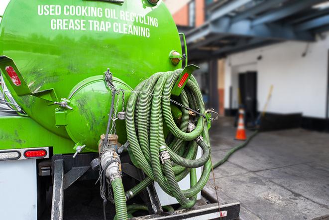 worker pumping grease trap at commercial kitchen in Brentwood, NY